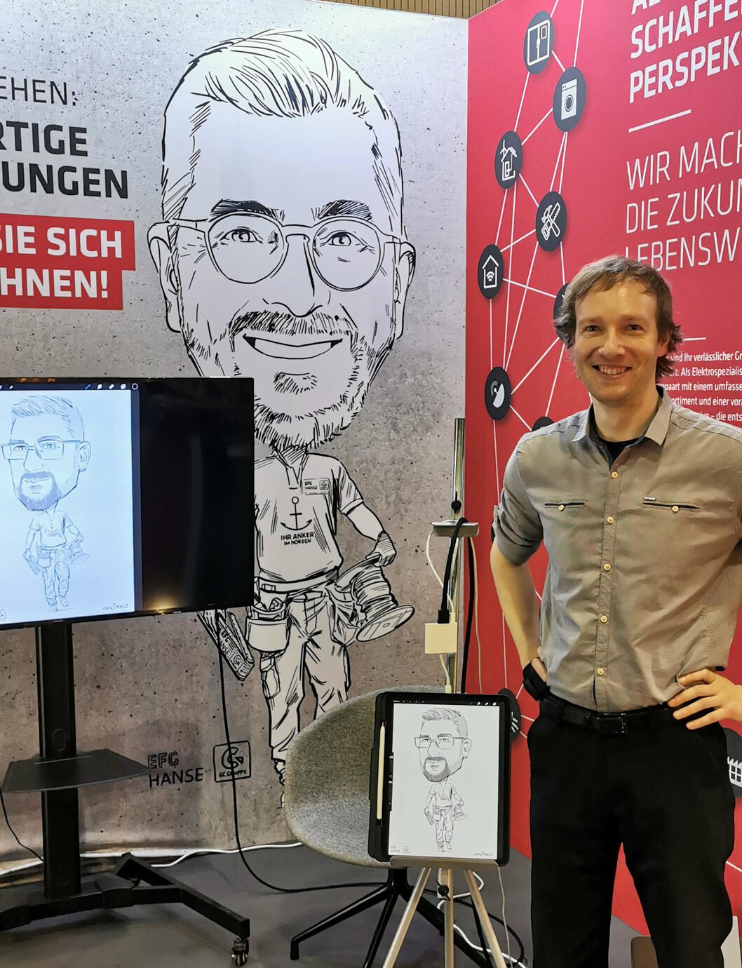 建設業界の展示会でのデジタル似顔絵実演。背景にはカスタム制作の企業ロゴ入り似顔絵 - 似顔絵師マキシム